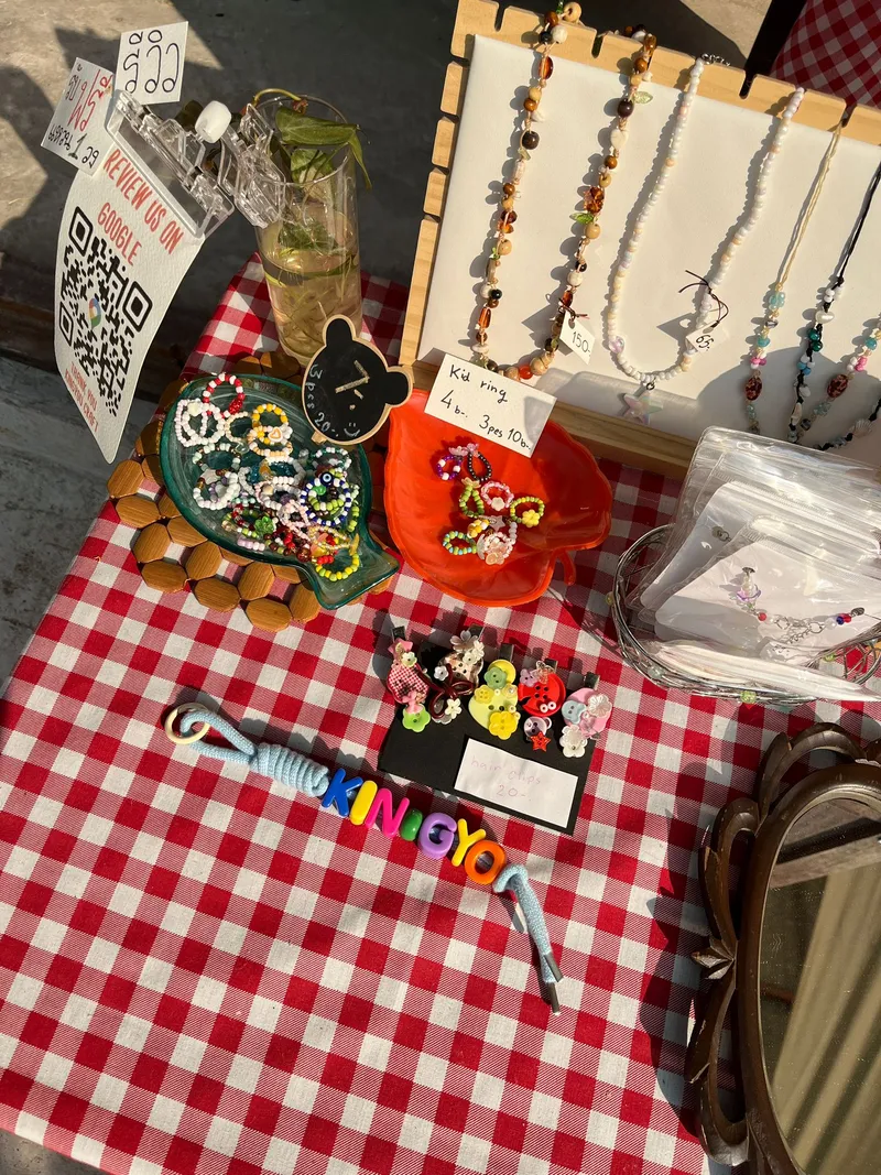 Handmade bead jewelry display on checkered tablecloth.