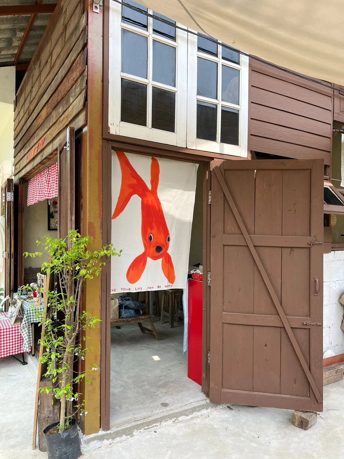 Entrance of a craft workshop with an orange fish banner.